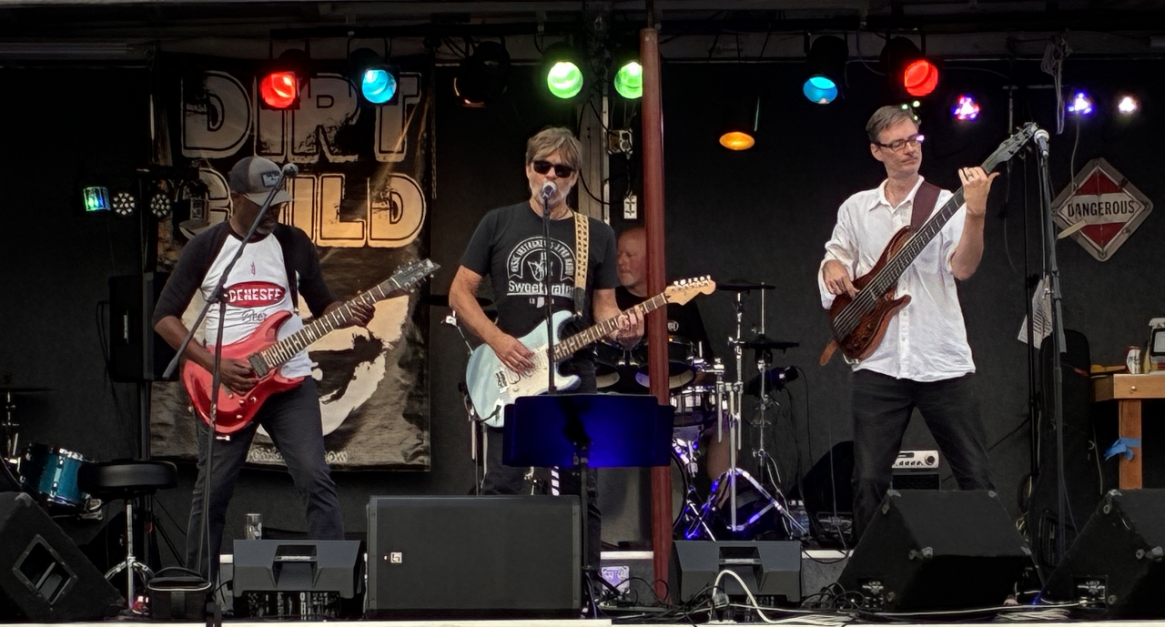 Dirt Child performing live on an outdoor stage at Gem Creek beneath the Dirt Child banner